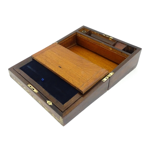 1553 - A Victorian writing slope with brass mounts, opening to reveal a fitted interior with two small conc... 