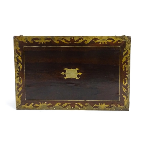 1553 - A Victorian writing slope with brass mounts, opening to reveal a fitted interior with two small conc... 