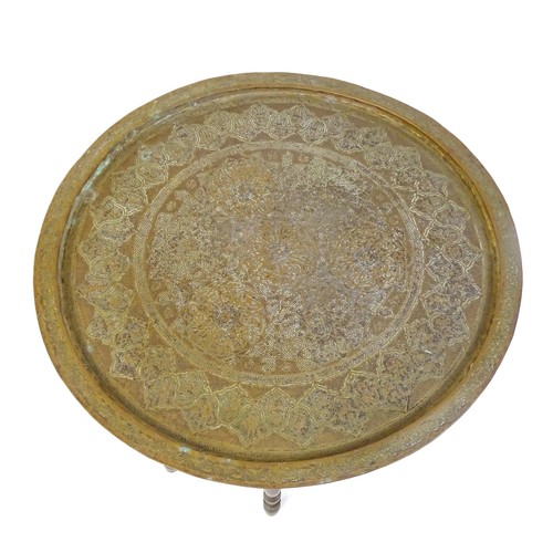 243 - An Islamic brass top table with a folding base. 25