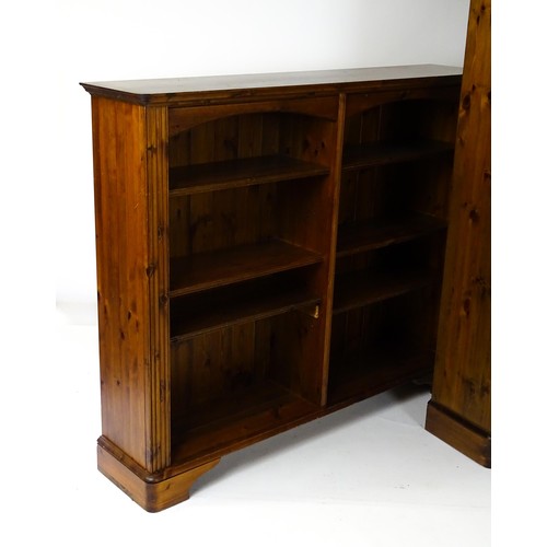 664 - Two modern pine bookcases with moulded cornices and raised on bracket feet. The tall bookcase 39