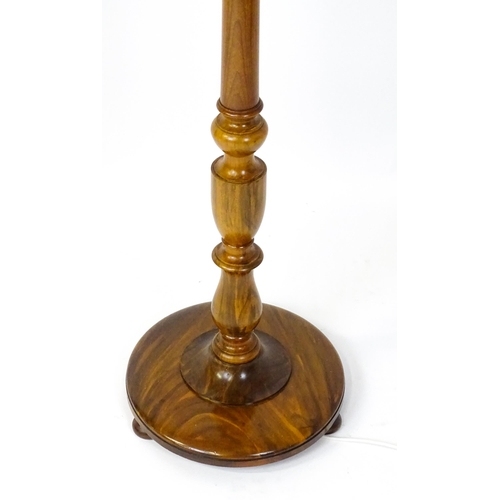 1683 - A turned wooden standard lamp raised on squat bun feet. Approx. 62