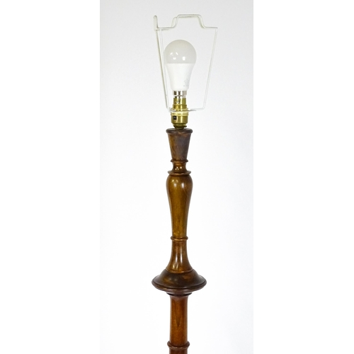 1683 - A turned wooden standard lamp raised on squat bun feet. Approx. 62