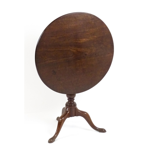 1710 - A Georgian mahogany tripod table with a one plank top above a turned pedestal base and raised on thr... 