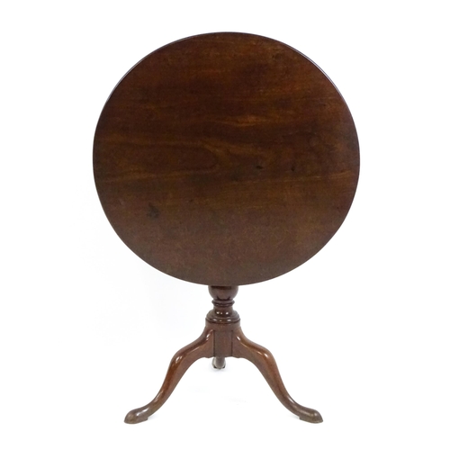 1710 - A Georgian mahogany tripod table with a one plank top above a turned pedestal base and raised on thr... 