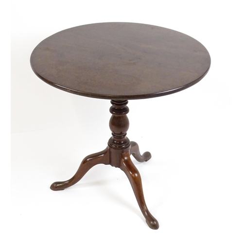 1710 - A Georgian mahogany tripod table with a one plank top above a turned pedestal base and raised on thr... 