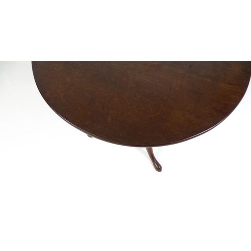 1710 - A Georgian mahogany tripod table with a one plank top above a turned pedestal base and raised on thr... 