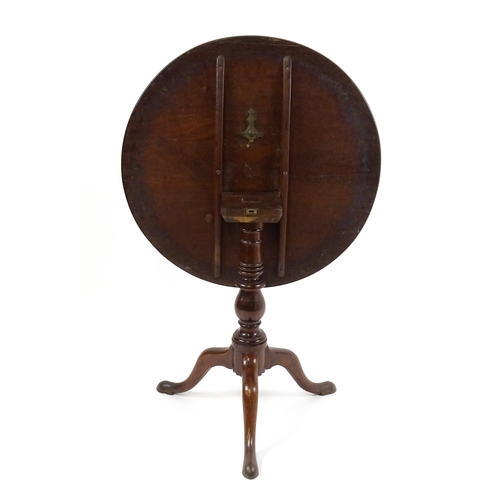 1710 - A Georgian mahogany tripod table with a one plank top above a turned pedestal base and raised on thr... 