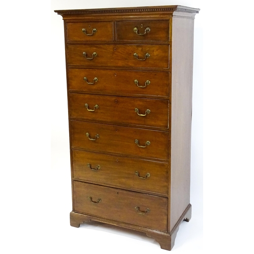 1718 - A Georgian mahogany tall boy / chest of drawers with a moulded cornice above a dentil carved frieze ... 