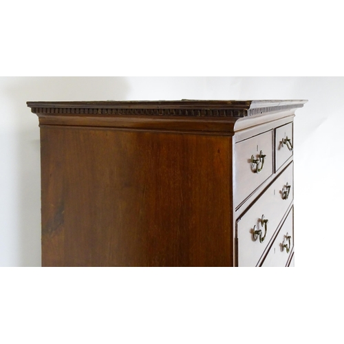 1718 - A Georgian mahogany tall boy / chest of drawers with a moulded cornice above a dentil carved frieze ... 