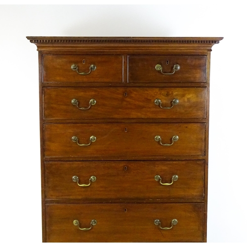 1718 - A Georgian mahogany tall boy / chest of drawers with a moulded cornice above a dentil carved frieze ... 