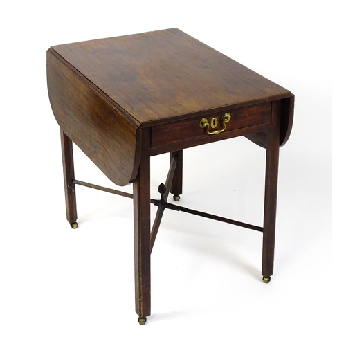 1733 - A Georgian mahogany drop flap table with two rounded leaves above a single frieze drawer with brass ... 