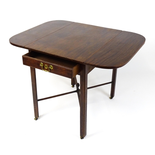 1733 - A Georgian mahogany drop flap table with two rounded leaves above a single frieze drawer with brass ... 