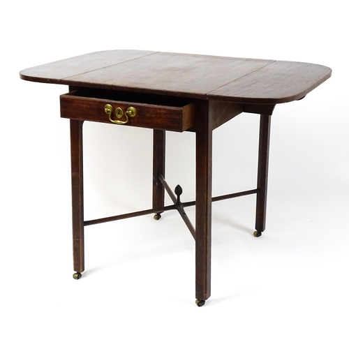 1733 - A Georgian mahogany drop flap table with two rounded leaves above a single frieze drawer with brass ... 