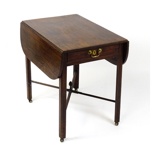 1733 - A Georgian mahogany drop flap table with two rounded leaves above a single frieze drawer with brass ... 