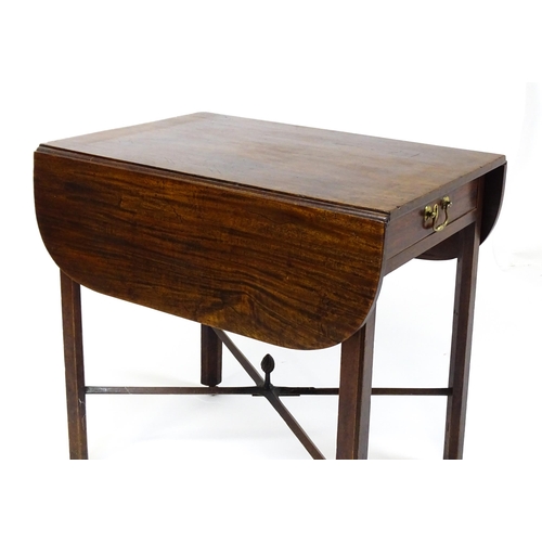 1733 - A Georgian mahogany drop flap table with two rounded leaves above a single frieze drawer with brass ... 