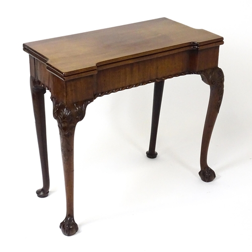 1734 - An 18thC Chippendale style card table with a hinged, inverted breakfront top above carved cabriole f... 