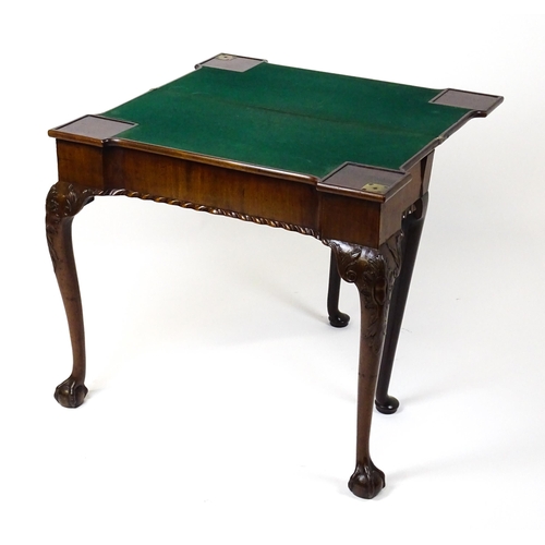 1734 - An 18thC Chippendale style card table with a hinged, inverted breakfront top above carved cabriole f... 