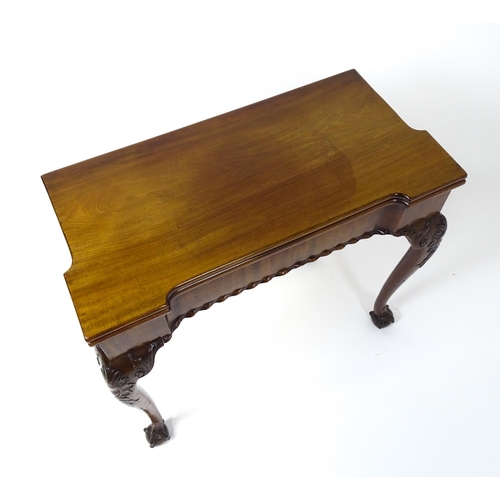 1734 - An 18thC Chippendale style card table with a hinged, inverted breakfront top above carved cabriole f... 