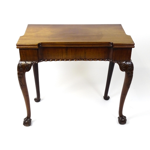 1734 - An 18thC Chippendale style card table with a hinged, inverted breakfront top above carved cabriole f... 