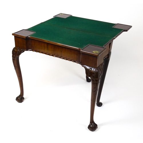 1734 - An 18thC Chippendale style card table with a hinged, inverted breakfront top above carved cabriole f... 