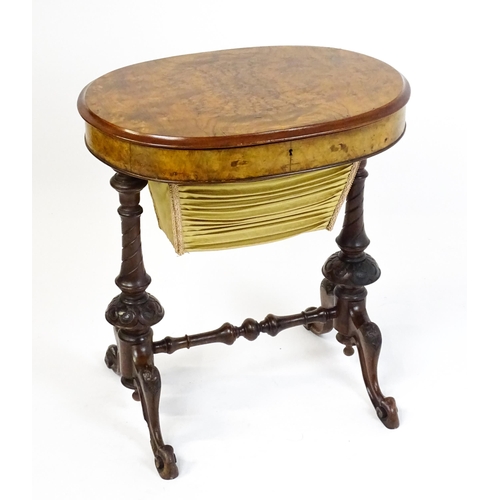 1756 - A late 19thC walnut sewing table with an oval hinged top above two turned and carved pedestals raise... 