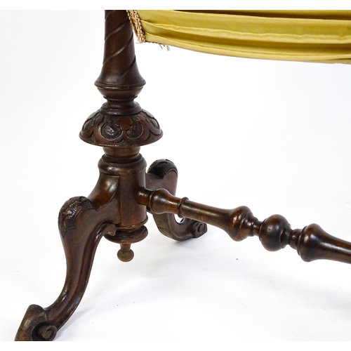 1756 - A late 19thC walnut sewing table with an oval hinged top above two turned and carved pedestals raise... 