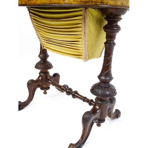 1756 - A late 19thC walnut sewing table with an oval hinged top above two turned and carved pedestals raise... 