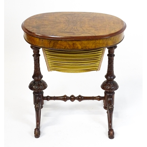 1756 - A late 19thC walnut sewing table with an oval hinged top above two turned and carved pedestals raise... 