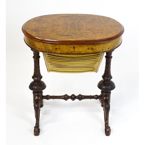 1756 - A late 19thC walnut sewing table with an oval hinged top above two turned and carved pedestals raise... 