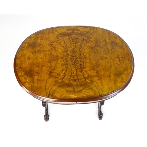 1756 - A late 19thC walnut sewing table with an oval hinged top above two turned and carved pedestals raise... 