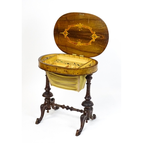 1756 - A late 19thC walnut sewing table with an oval hinged top above two turned and carved pedestals raise... 