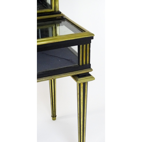 1758 - A 19hC vitrine with two glass doors lined with brass mouldings above a base with a hinged lid and ra... 