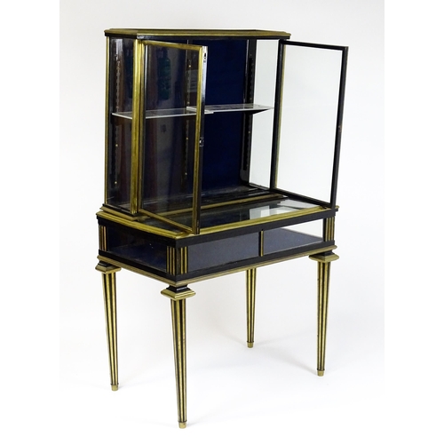 1758 - A 19hC vitrine with two glass doors lined with brass mouldings above a base with a hinged lid and ra... 