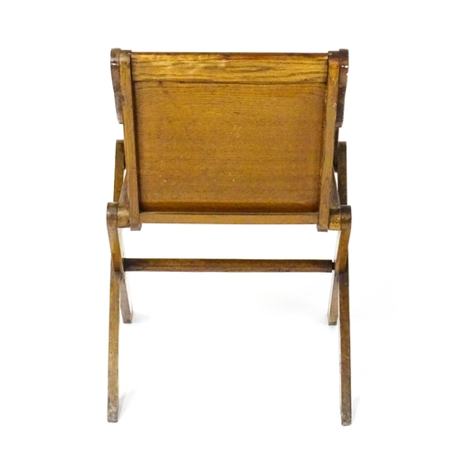 1760 - A late 19thC / early 20thC oak Glastonbury chair with a painted armorial to the centre of the backre... 