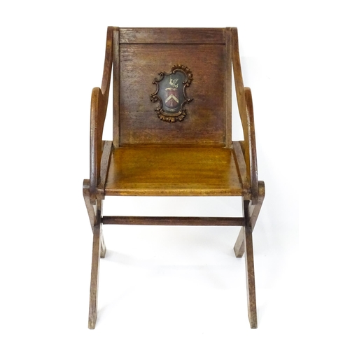 1760 - A late 19thC / early 20thC oak Glastonbury chair with a painted armorial to the centre of the backre... 