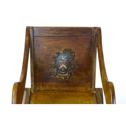 1760 - A late 19thC / early 20thC oak Glastonbury chair with a painted armorial to the centre of the backre... 