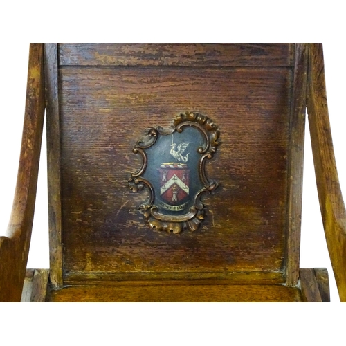 1760 - A late 19thC / early 20thC oak Glastonbury chair with a painted armorial to the centre of the backre... 