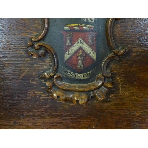 1760 - A late 19thC / early 20thC oak Glastonbury chair with a painted armorial to the centre of the backre... 