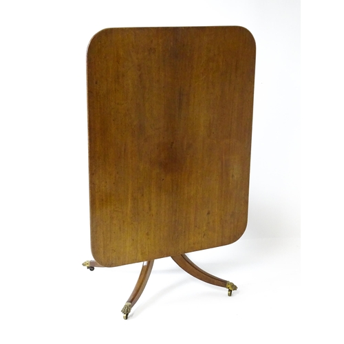 1762 - A Victorian mahogany breakfast table with an oblong tilt top above a turned pedestal and four sabre ... 