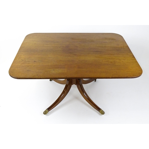 1762 - A Victorian mahogany breakfast table with an oblong tilt top above a turned pedestal and four sabre ... 