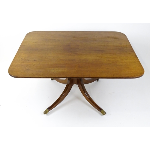 1762 - A Victorian mahogany breakfast table with an oblong tilt top above a turned pedestal and four sabre ... 