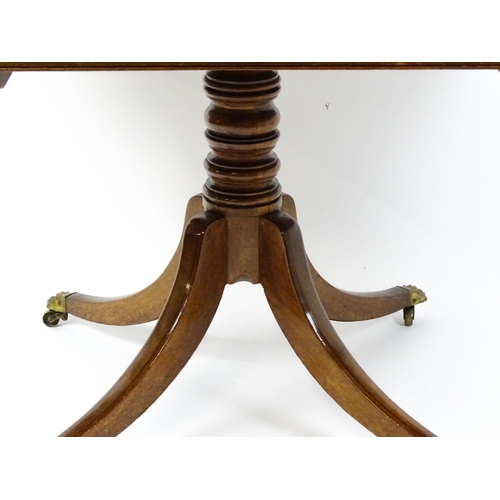 1762 - A Victorian mahogany breakfast table with an oblong tilt top above a turned pedestal and four sabre ... 