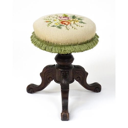 1764 - A late 19thC walnut piano stool with an adjustable needlework top raised on three carved cabriole le... 