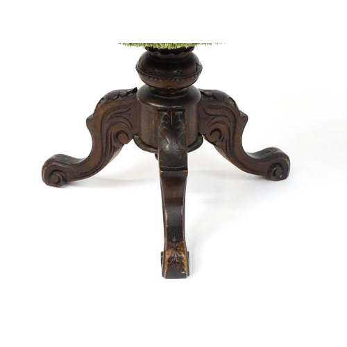 1764 - A late 19thC walnut piano stool with an adjustable needlework top raised on three carved cabriole le... 