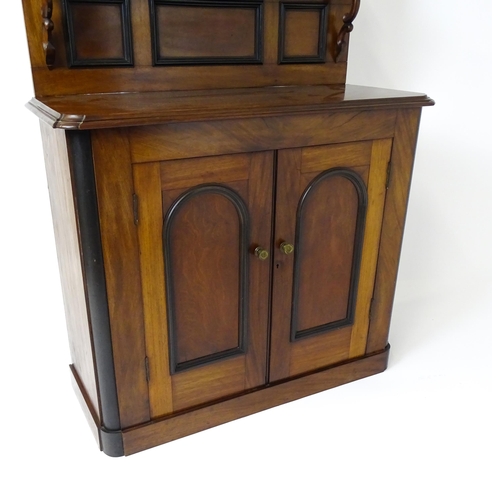 1796 - A small Victorian mahogany chiffonier with a carved upstand having a small shelf and two panelled cu... 