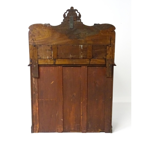 1796 - A small Victorian mahogany chiffonier with a carved upstand having a small shelf and two panelled cu... 