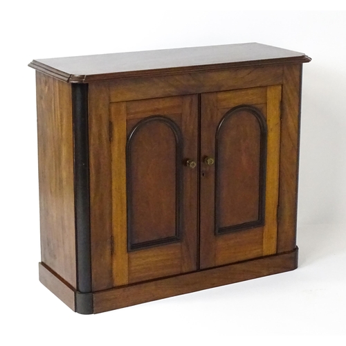 1796 - A small Victorian mahogany chiffonier with a carved upstand having a small shelf and two panelled cu... 