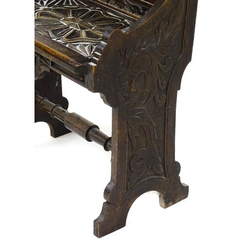 1797 - A Victorian carved oak chair with a pointed pediment above a panelled backrest and floral carved sea... 