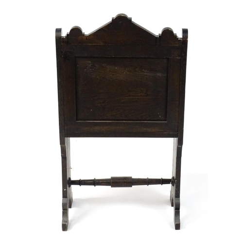 1797 - A Victorian carved oak chair with a pointed pediment above a panelled backrest and floral carved sea... 