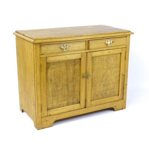 1802 - A late 19thC / early 20thC pine cupboard with a moulded top above two short drawers and two panelled... 